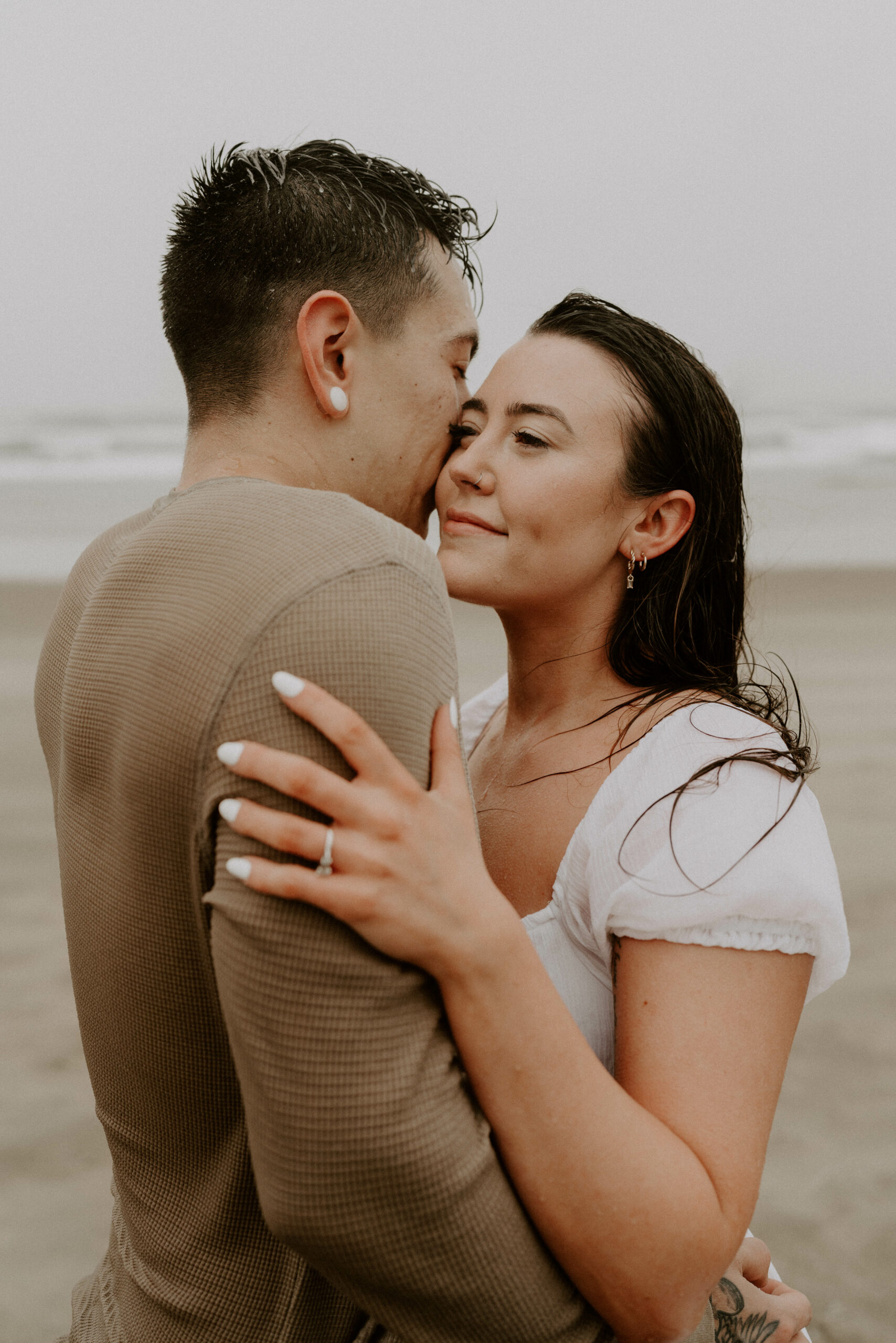 Couple Taking Engagement Photos On Beach During Wind Storm
